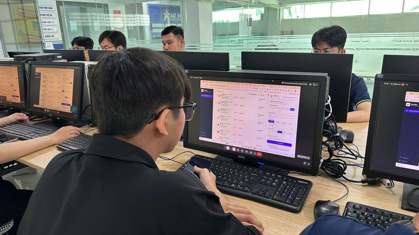 Học viên theo dõi máy tính và laptop trong buổi thực hành