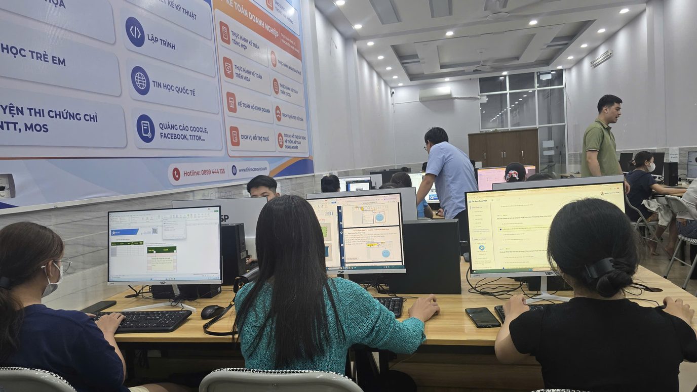 Giảng viên và học viên trao đổi trong phòng máy